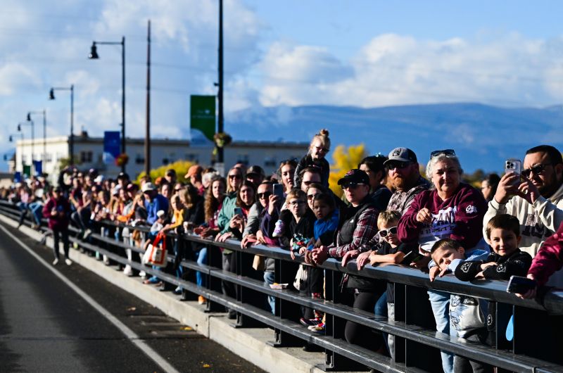 Crowd of people watches parade on Higgins Ave. bridge