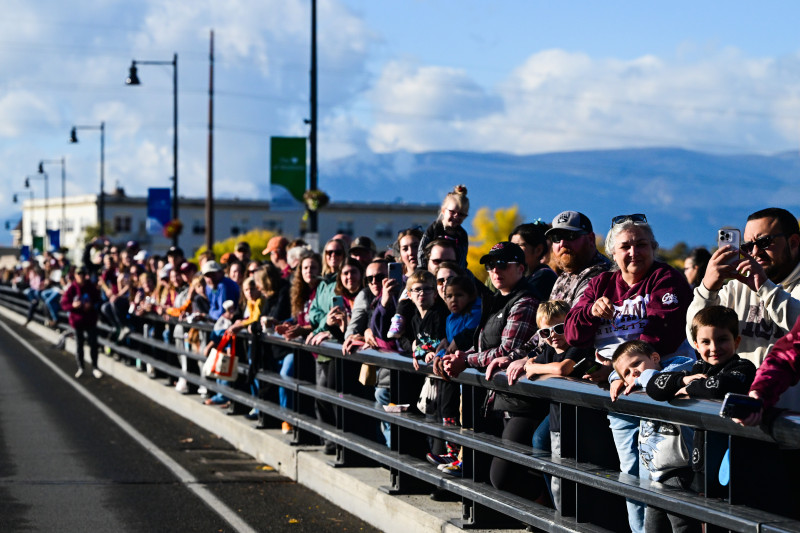 Crowd of people watches parade on Higgins Ave. bridge