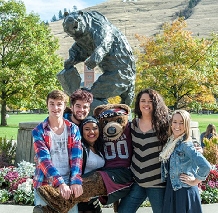 group of students with Monte in front of bear statue