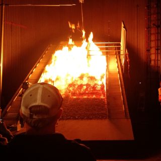Students look at the burn chamber at the Missoula Fire Lab, a leading federal research facility 