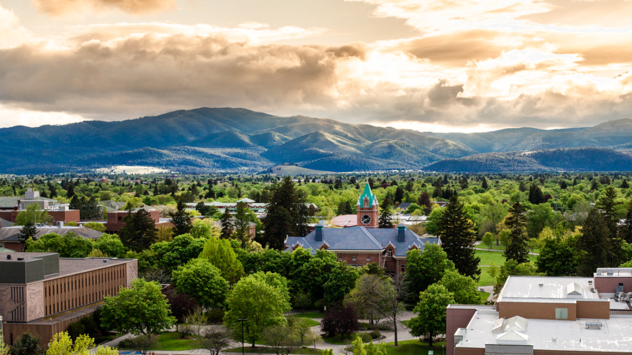 Colorful fall leaves are scattered across the Oval, Main Hall stands in the background
