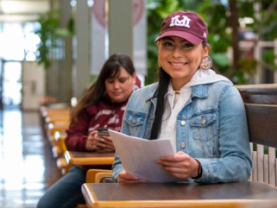 Student smiling while wearing UM hat