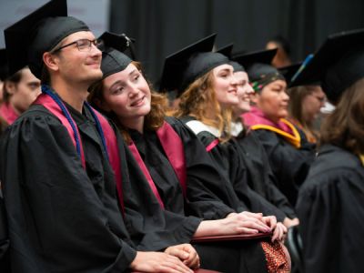 Student smiling while wearing UM hat