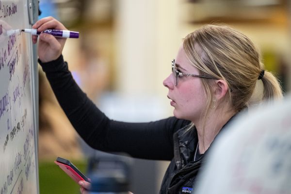 A student writes on a whiteboard