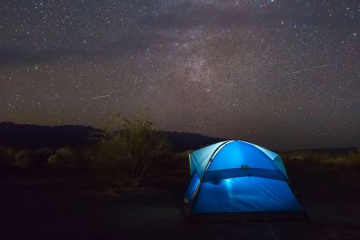 A tent glows under the stars.