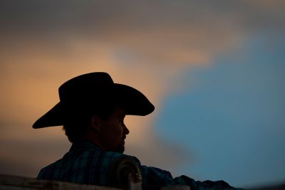 A silhouette of a cowboy at sunset.