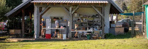 A small open-air kitchen under the gabled straw bale barn on a sunny day at the �Թ��� PEAS Farm in Missoula, MT.
