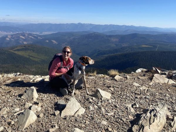 Graduate Student, Jenny Rotzal, on top of a mountain next to her dog