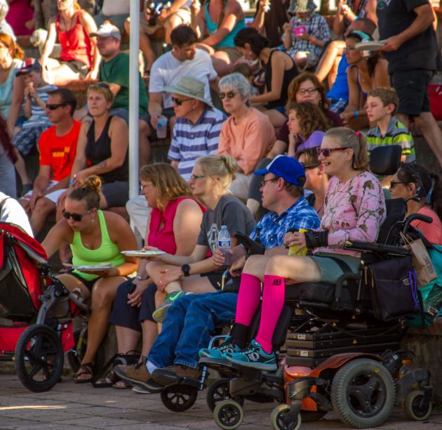 Woman in a wheelchair in crowd of an outdoor concert