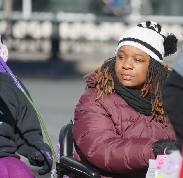 Woman in wheelchair participating in outdoor march