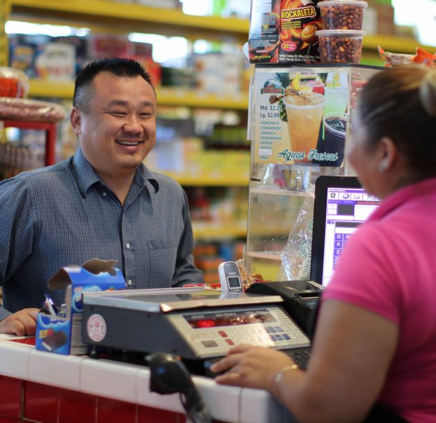 Man purchasing product from cashier at small business