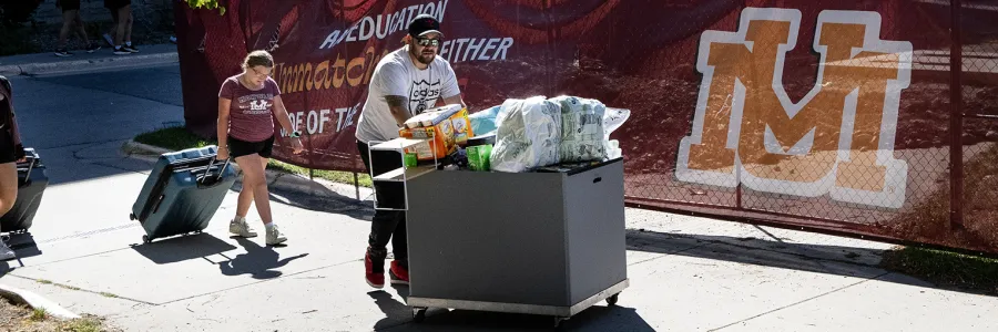 A father helps students move into UM residence falls.