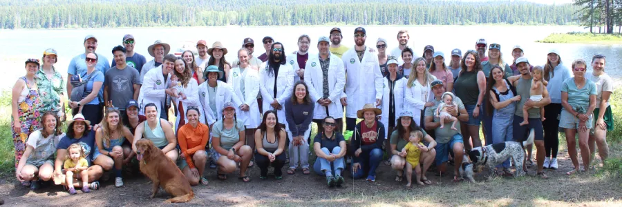 Members of Western Montana Family Medicine posing together on the banks of a lake.