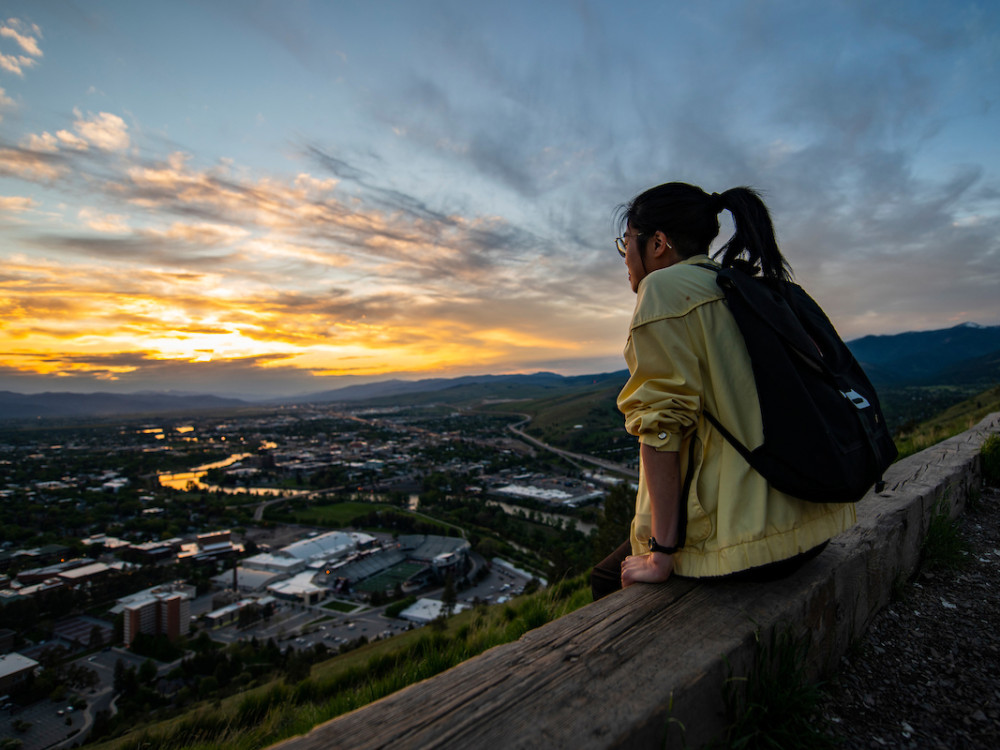 A student overlooks the Missoula Valley from the M on Mount Sentinel