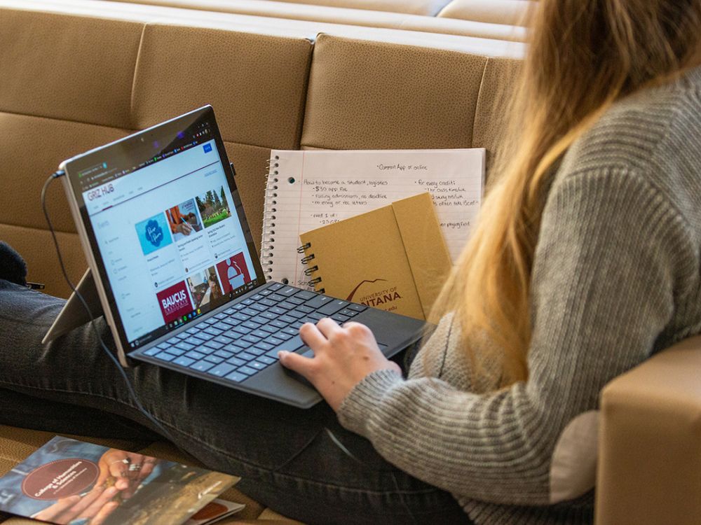 A UM student works online on a laptop