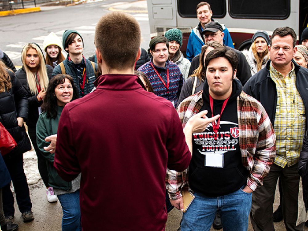 A UM tour guide leads a group across campus