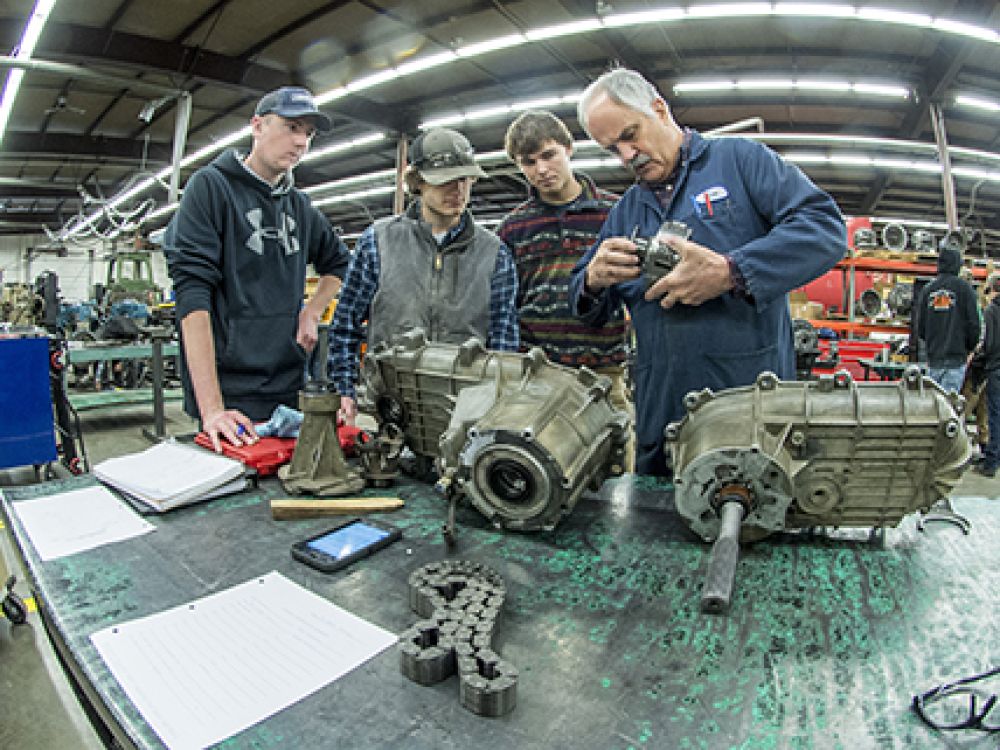 Missoula College students surround a machine for a technology career fair. 