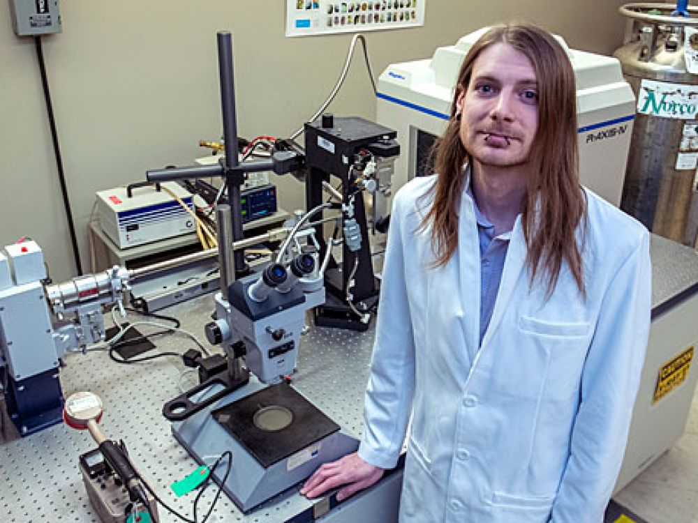 Sascha Stump poses for the camera while standing in his lab at UM