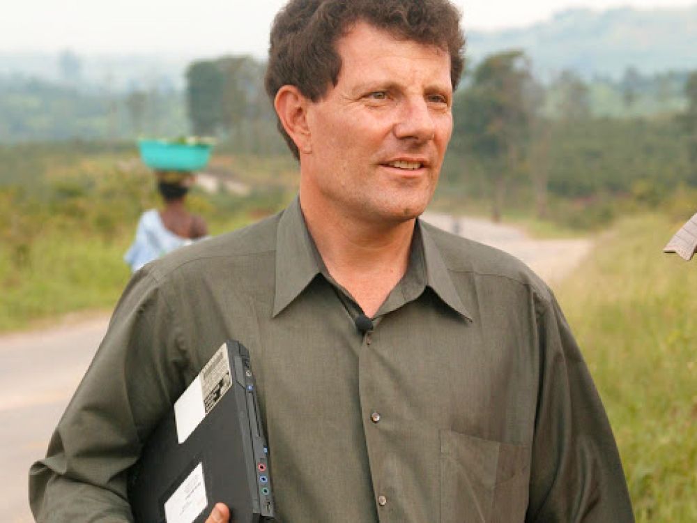 Nicholas Krisof in a green shirt carrying a laptop 
