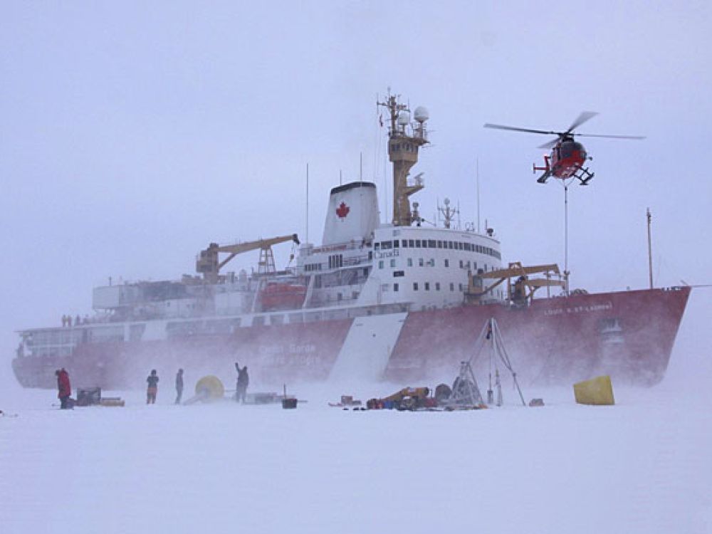 Crew members deploy equipment onto the ice from a Canadian icebreaker.