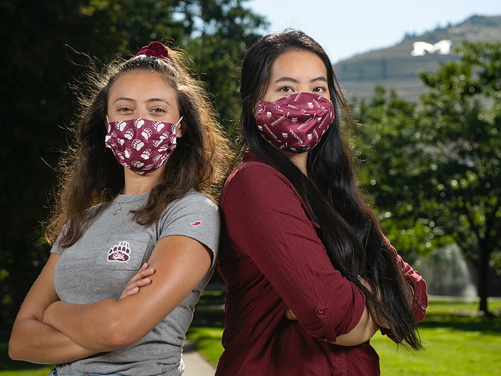 Two female UM students pose for picture with masks