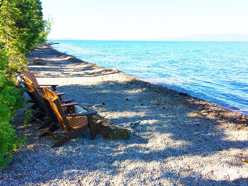 A picture of lawn chairs on a new rocky beach at Flathead Lake