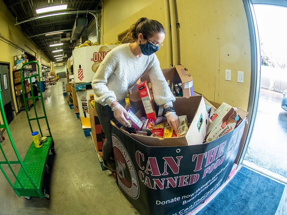 Molly Kirkham, an AmeriCorps team leader with the Missoula Food Bank, looks over some of the 672,000 pounds of food donations produced by Can the Cats.