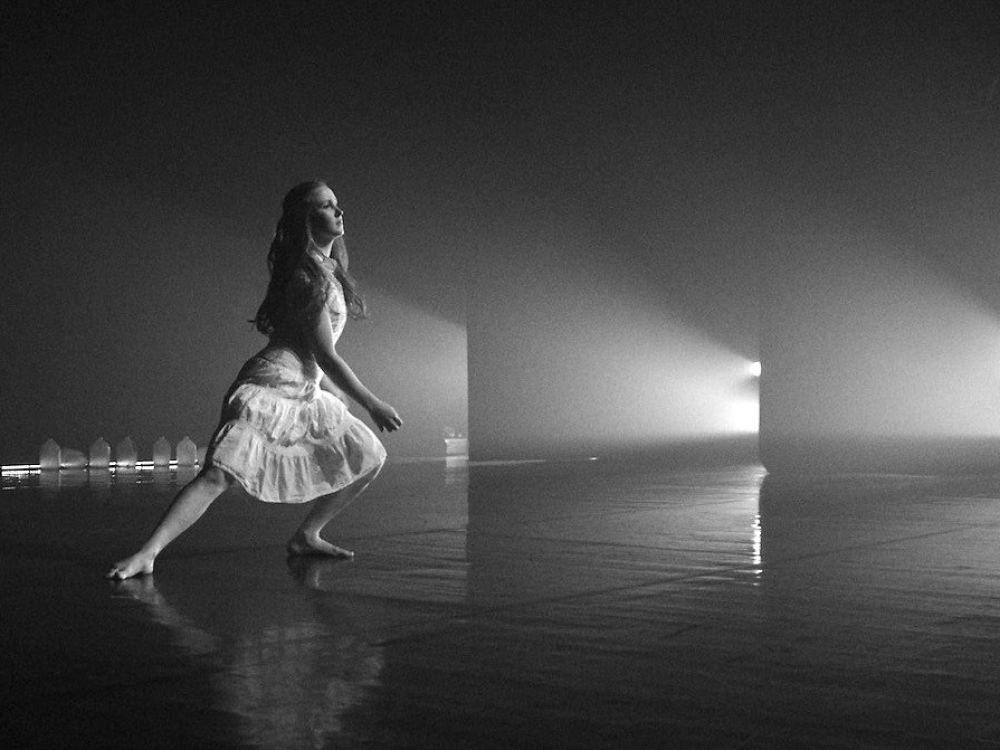 A black-white-photo of a female UM student dancing