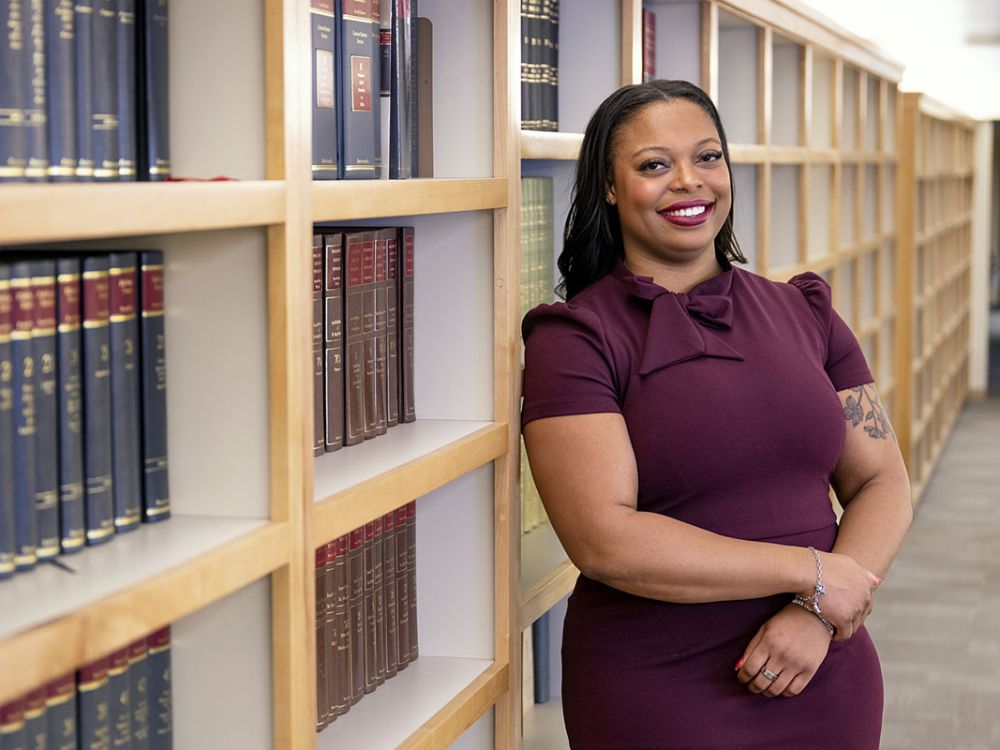 A picture of Alicia Miles with law books behind her.