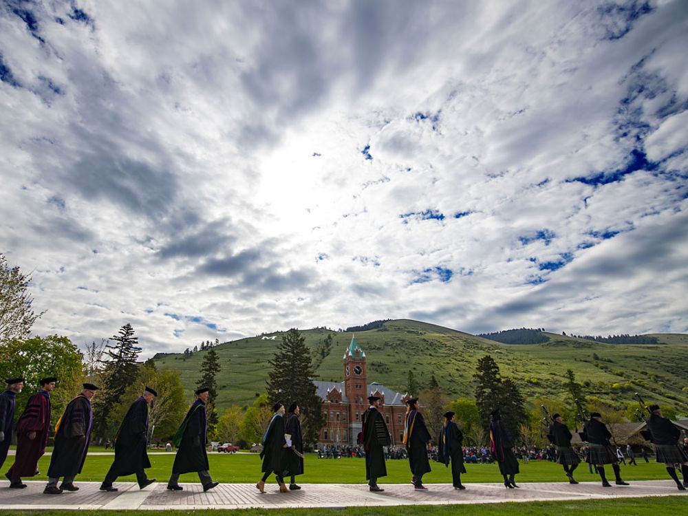 Administrators in graduation attire line up on the UM Oval.