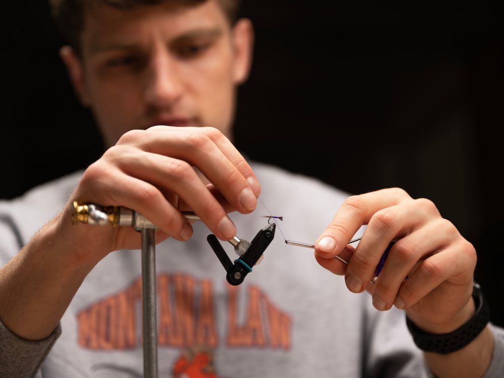 Photo of Henry Charpentier tying fly.