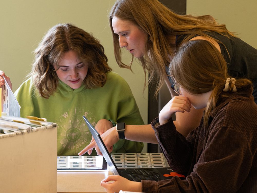 Photo of students looking at photo slide sleeves