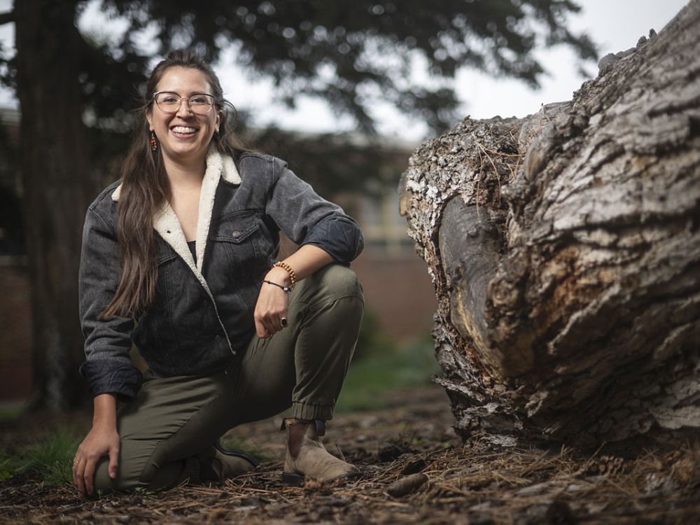 Stephanie Barron poses near a tree stump on campus.