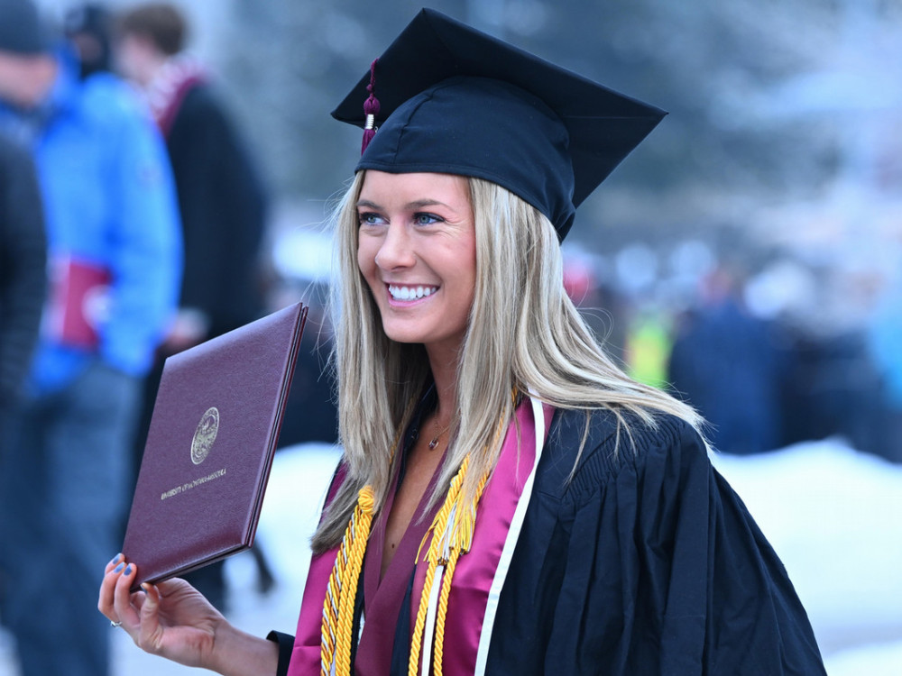 A 2023 graduate holds up her diploma cover