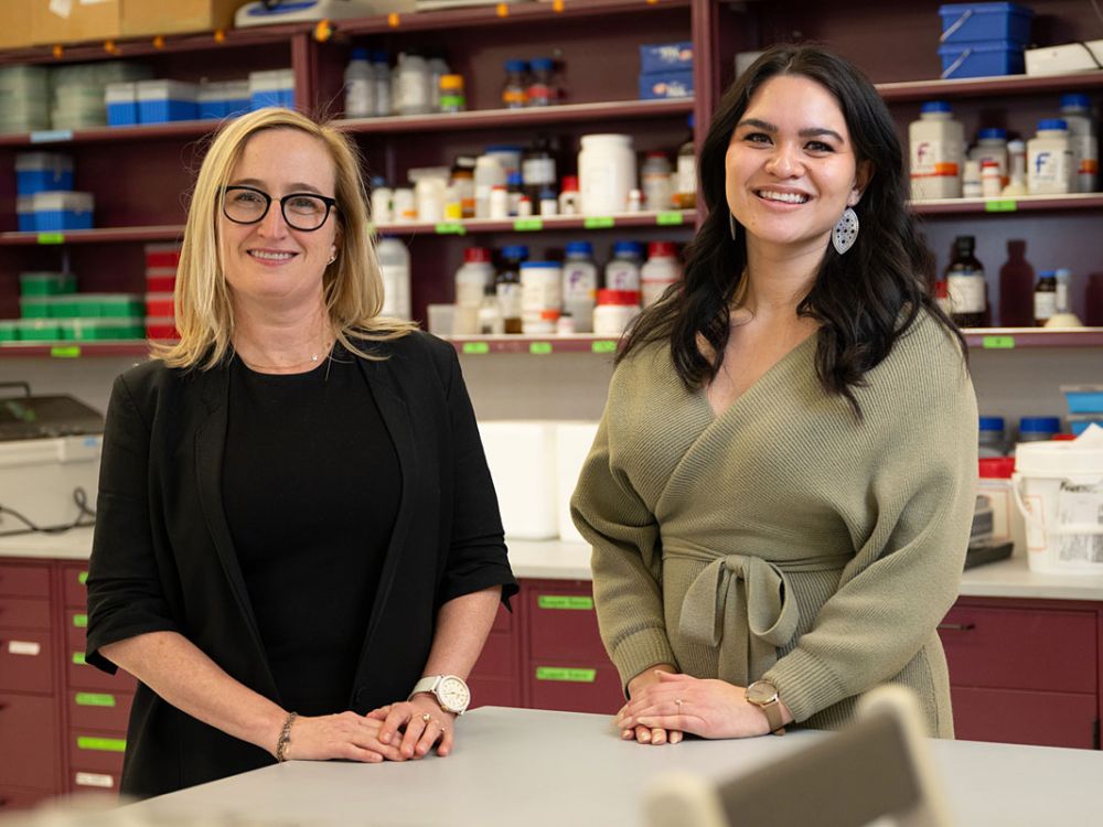 Researchers Erica Woodahl and Karen Brown pose for a photo in a UM lab.