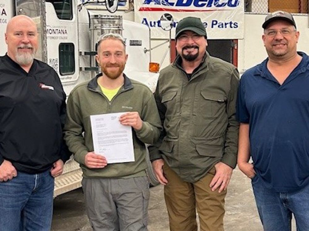 Four men with Missoula College and Modern Machinery pose for a photo