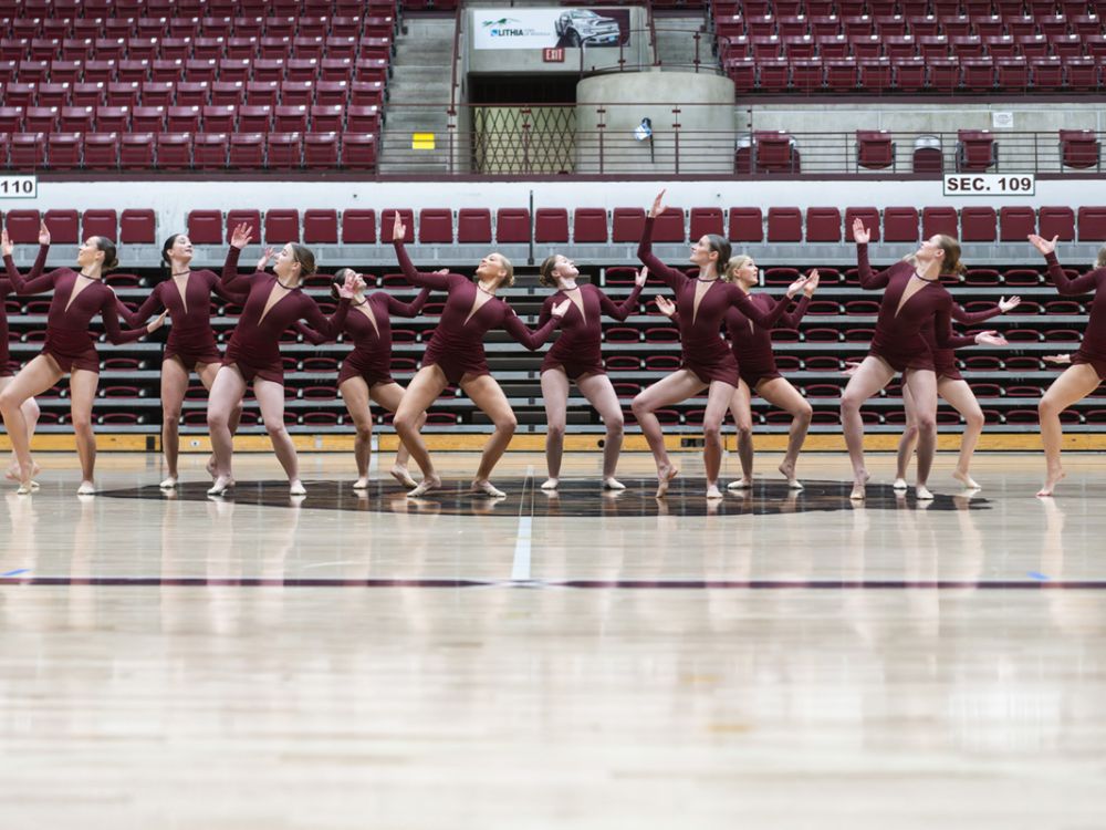 An image of the UM Dance Team practicing in their competition uniforms. 