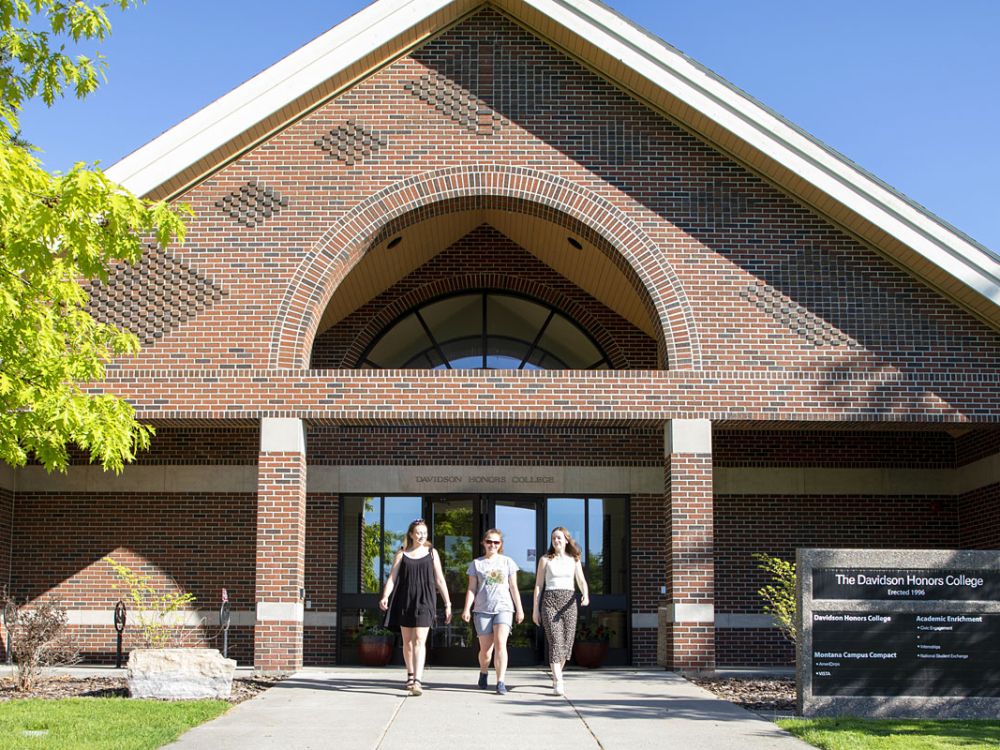 Students walk in front of the Davidson Honors College.