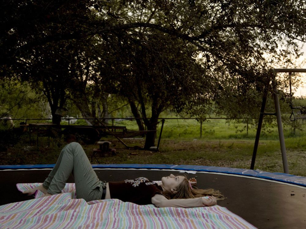 A girl rests on a trampoline in a Pulitzer Prize-winning photo.