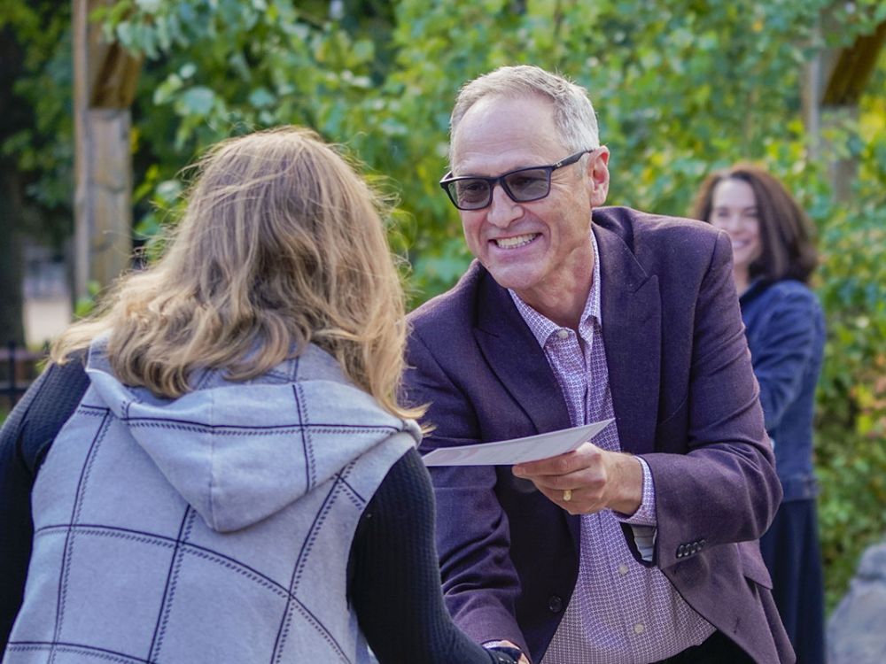 Davidson Honors College Dean Tim Nichols shakes hand of student.