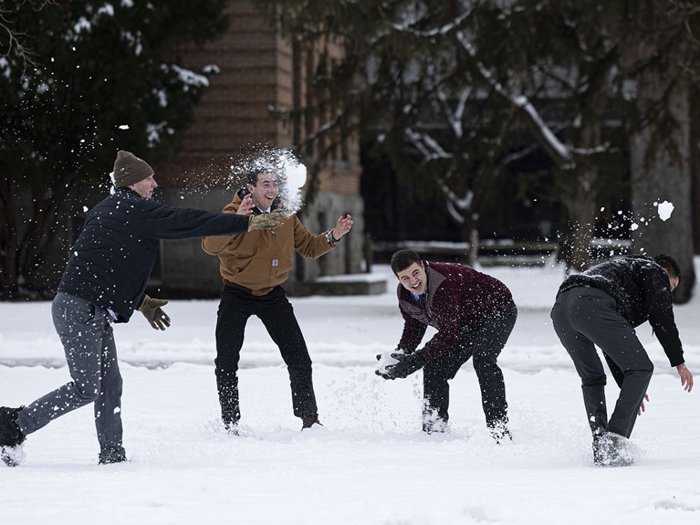 Male students have a snowball fight at UM.