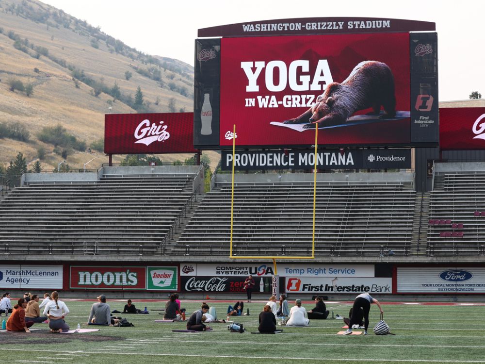 An image of people doing yoga in Washington-Grizzly Stadium. 