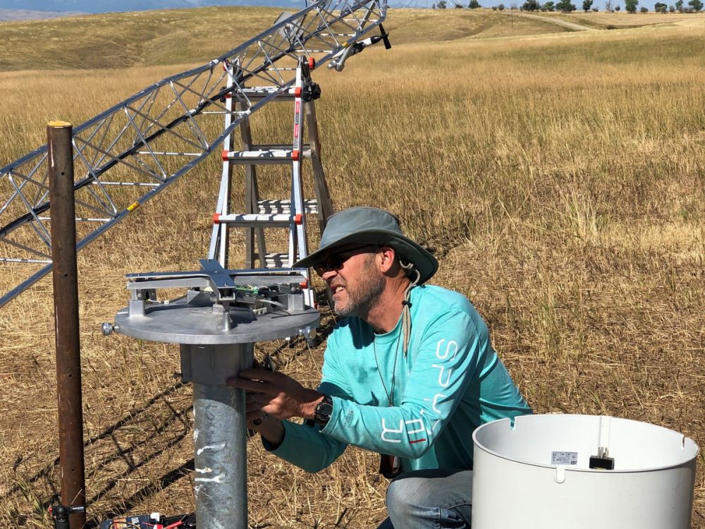 An individual installs a precipitation gauge.