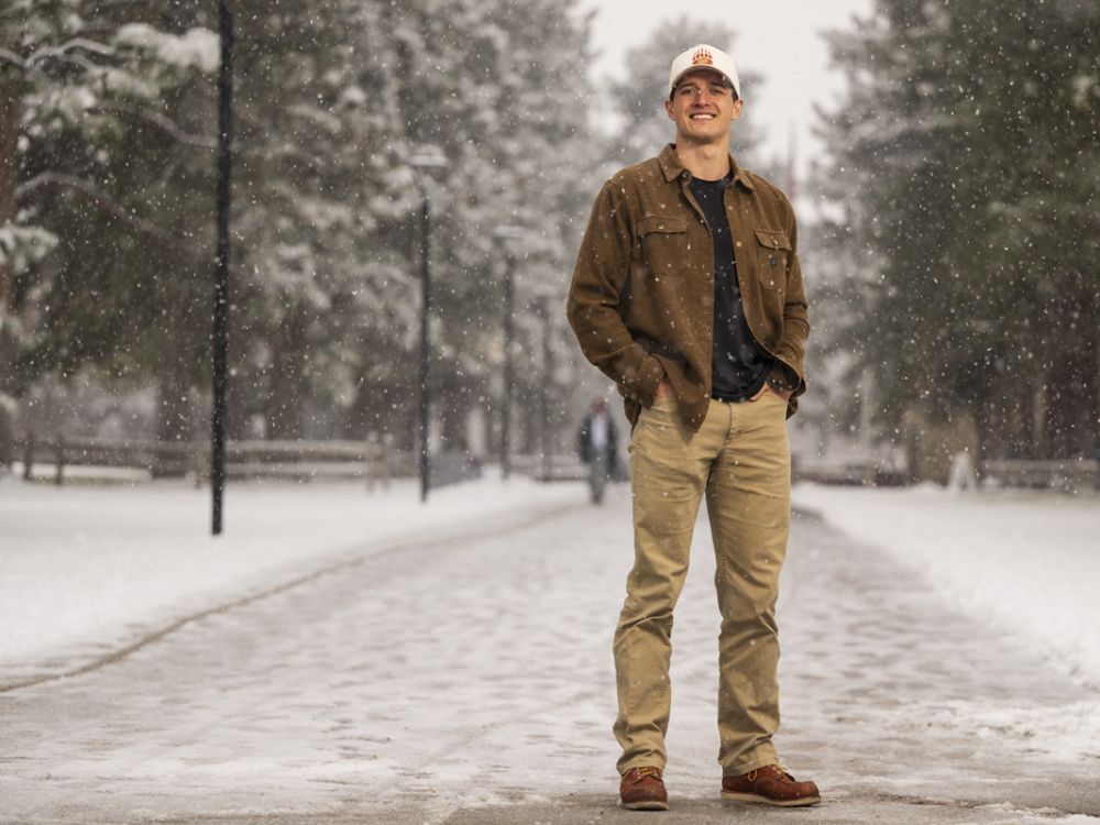 91��Ԫ student James Straw stands for a photo in the falling snow on Memorial Row on campus.
