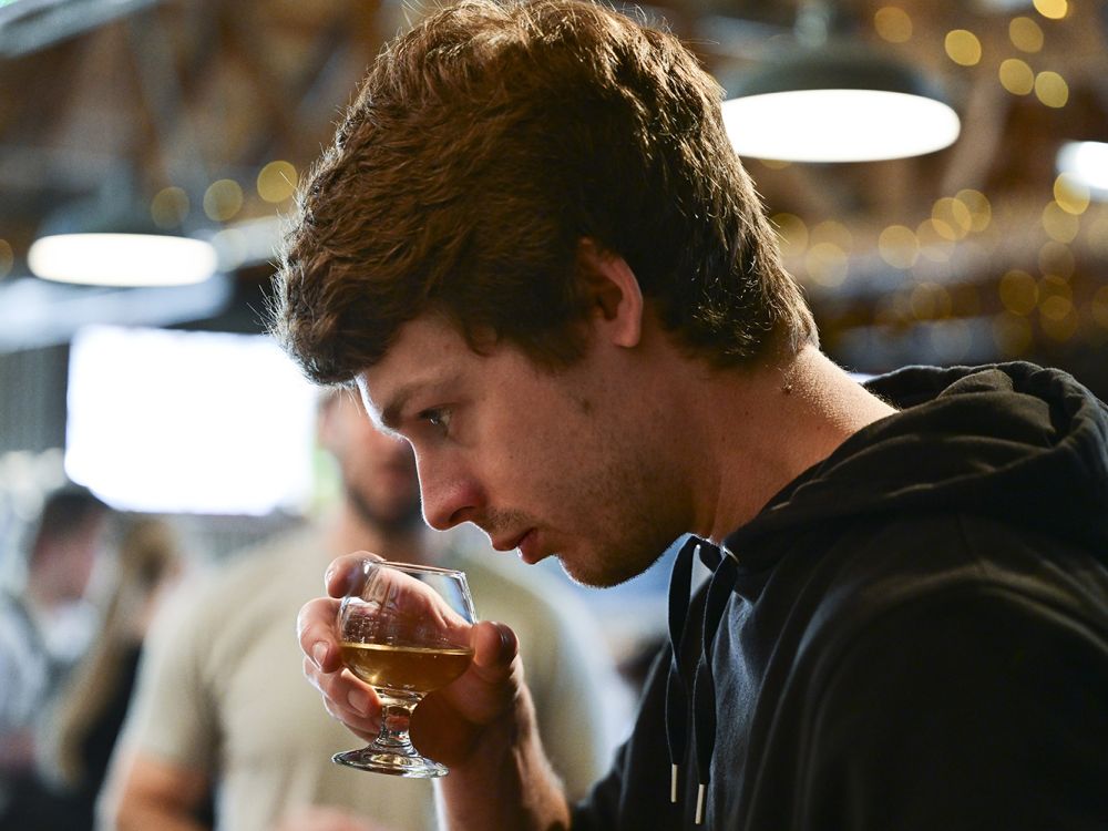 A student smells a sample of beer 