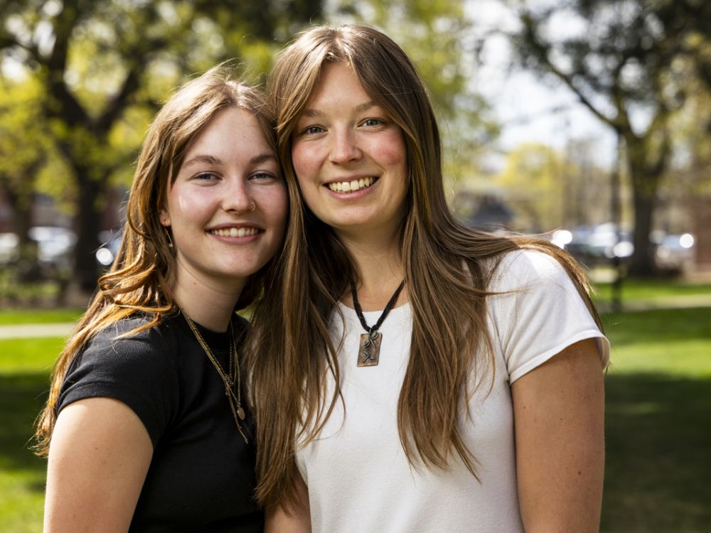 Cadence Hatten, pictured to the left of the image, and Vivianne Ostheimer smile for a portrait photo together on a sunny spring day.