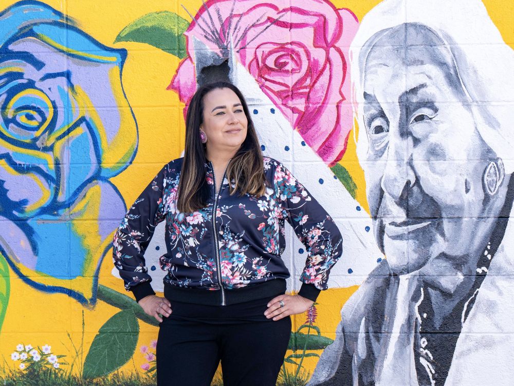 Christie Farmer stands in front of a mural. 