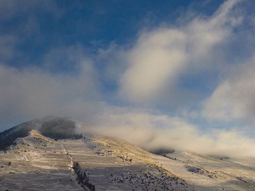 A mountain is covered in snow and fog 