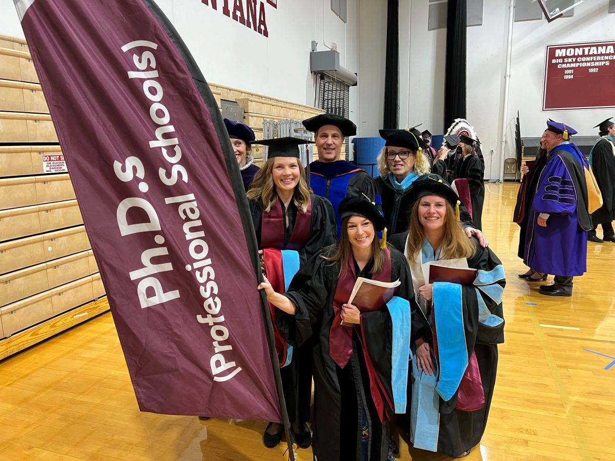 CoE doctoral graduates stand with faculty members at the 2022 Spring Commencement.