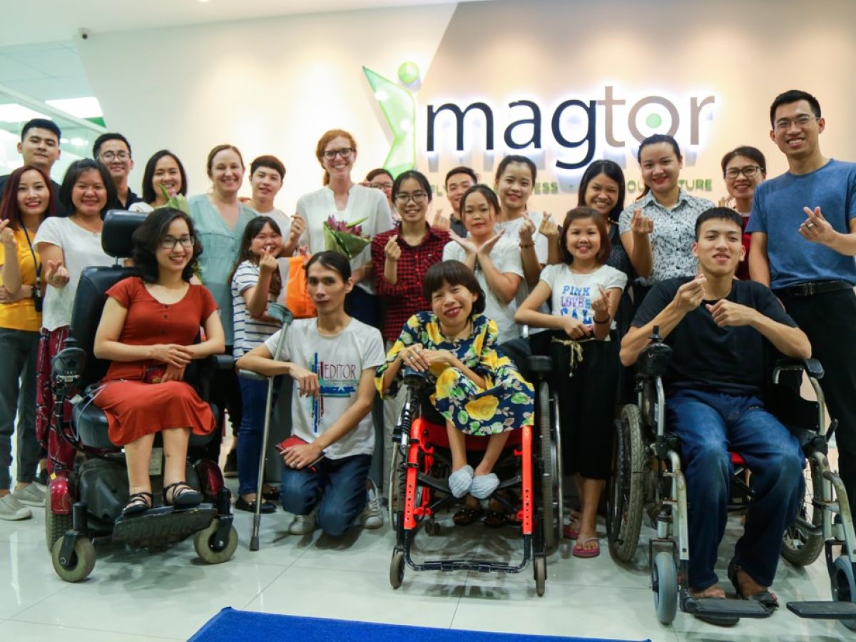 Group of people standing in front of a Imagtor sign.